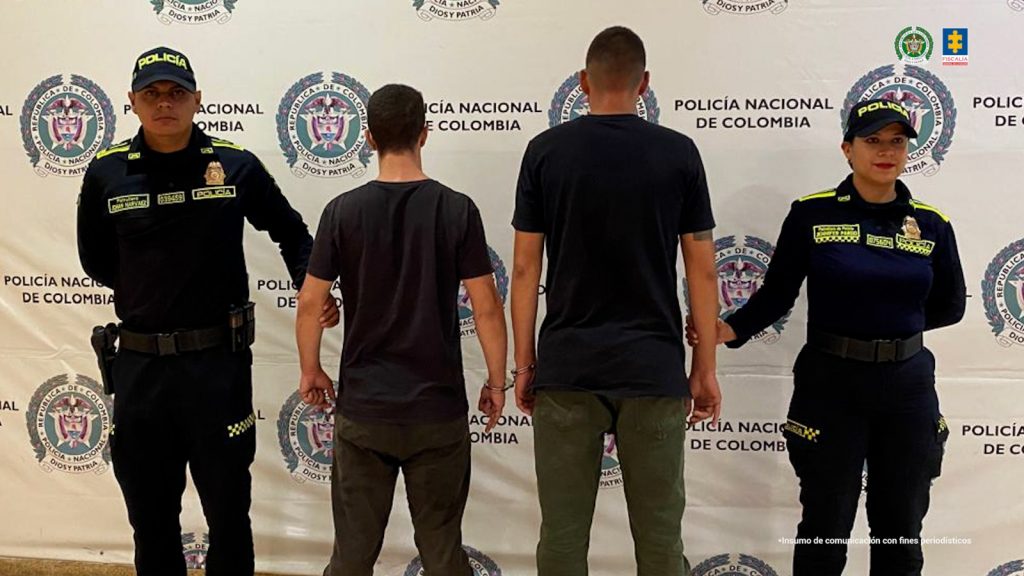 En la fotografía se encuentran cuatro personas dos de ellas los procesados, quienes se encuentran acompañados de dos uniformados de la Policía Nacional. 