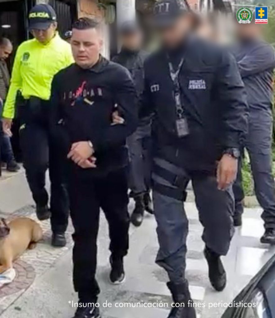 Se observa al capturado cuando es dirigido por la calle luego de su captura. Del brazo lo lleva un funcionario del CTI