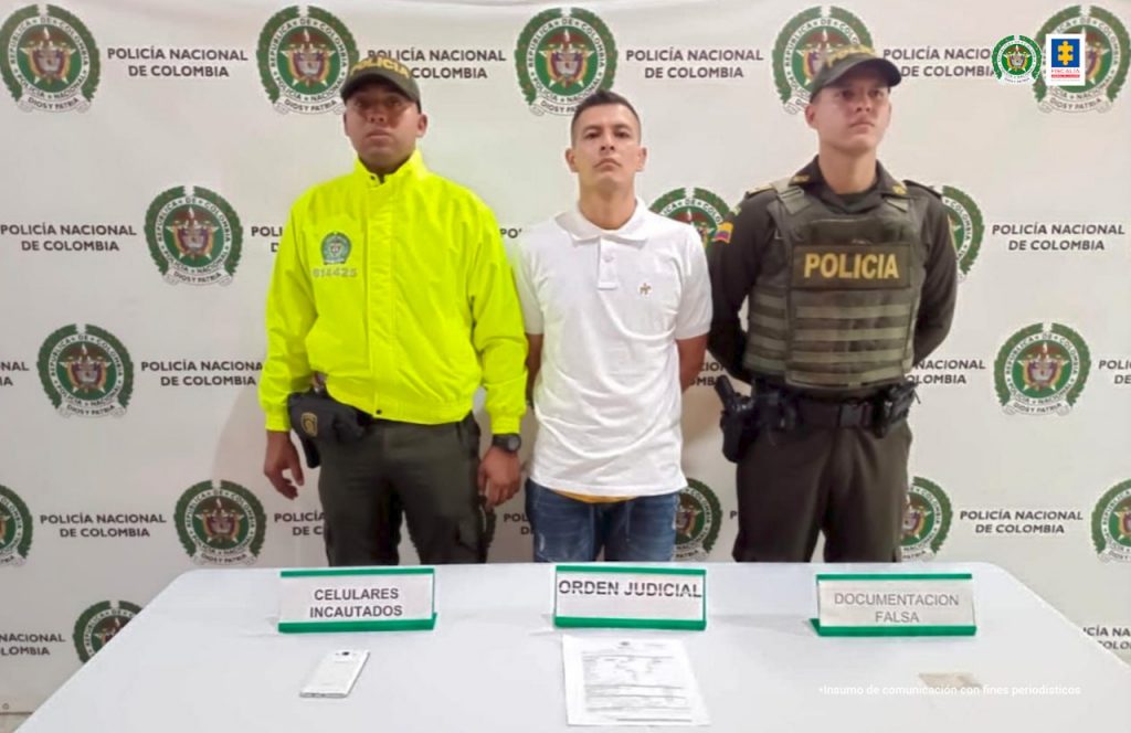 En la fotografía se encuentra el procesado con dos servidores de la Policía Nacional.