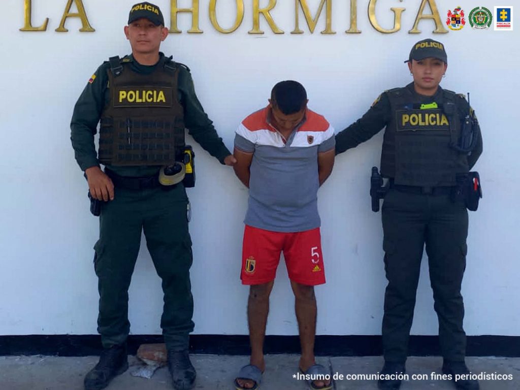 En la fotografía aparecen dos capturados, junto a personal de Policía Nacional. En la parte posterior de la imagen se ven banners de Policía Nacional y la Fiscalía General de la Nación.