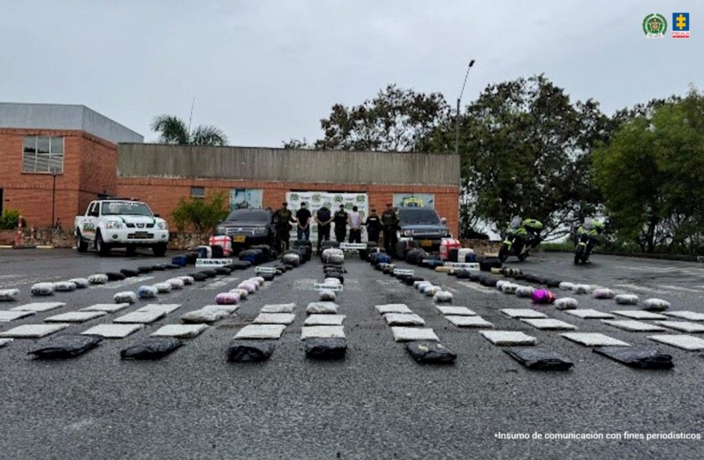 La fotografía fue tomada en exteriores. Aparecen de pie, con los brazos atrás, esposados y de espaldas a la cámara Róbinson Reyes Gil, Pedro Luis Rodríguez Pardo y Edgar Daniel Muñoz Hernández. Intercalados a ellos hay uniformados de la Policía Nacional. En la parte delantera y sobre el suelo se aprecian gran cantidad de paquetes envueltos en plástico transparente y negro. En los extremos también se aprecian dos vehículos particulares y uno de la Policía. En la parte posterior hay un pendón institucional de la Policía.