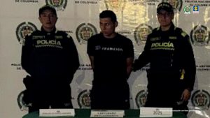 Se ve al acusado de hurto esposado, al lado de dos agentes de la Policía Nacional.