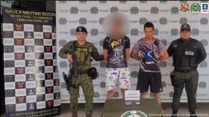 En la imagen aparecen dos personas detenidas entre uniformados de la Policía y el Ejército.