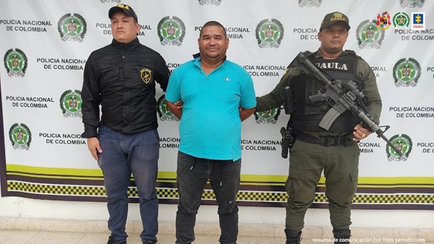 En la fotografía aparece en el centro un capturado y junto a él dos integrantes del Gaula del Ejército y de la Policía Nacional. En la parte posterior de ellos se encuentra el banner de la Policía Nacional