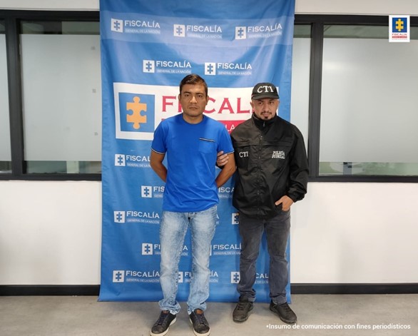 En la imagen se aprecia al procesado junto a un investigador de CTI. Detrás de ellos el banner que identifica a la Policía Nacional