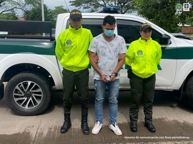 En la fotografía se aprecia el capturado junto a dos uniformados de la Policía Nacional y detrás de ellos una patrulla de la Policía Nacional.