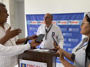 En la imagen se ve una persona en medio de una entrevista con periodistas.