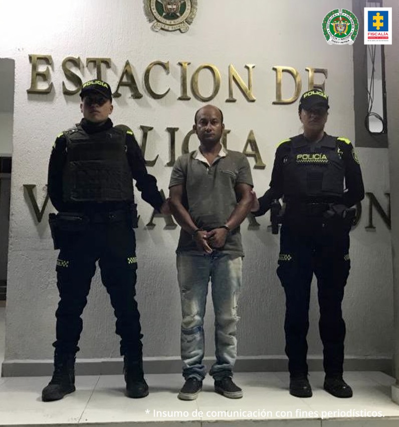 En la fotografía aparece un capturado junto a personal de Policía Nacional. En la parte posterior de la imagen se ven banners de Policía Nacional y Fiscalía General de la Nación.