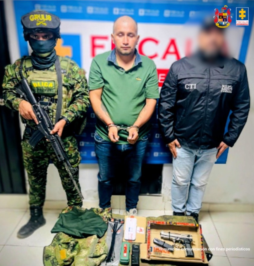 En la fotografía aparece el capturado junto a un funcionario el CTI y un soldado del Ejército. En la parte superior está un banner de la Fiscalía General