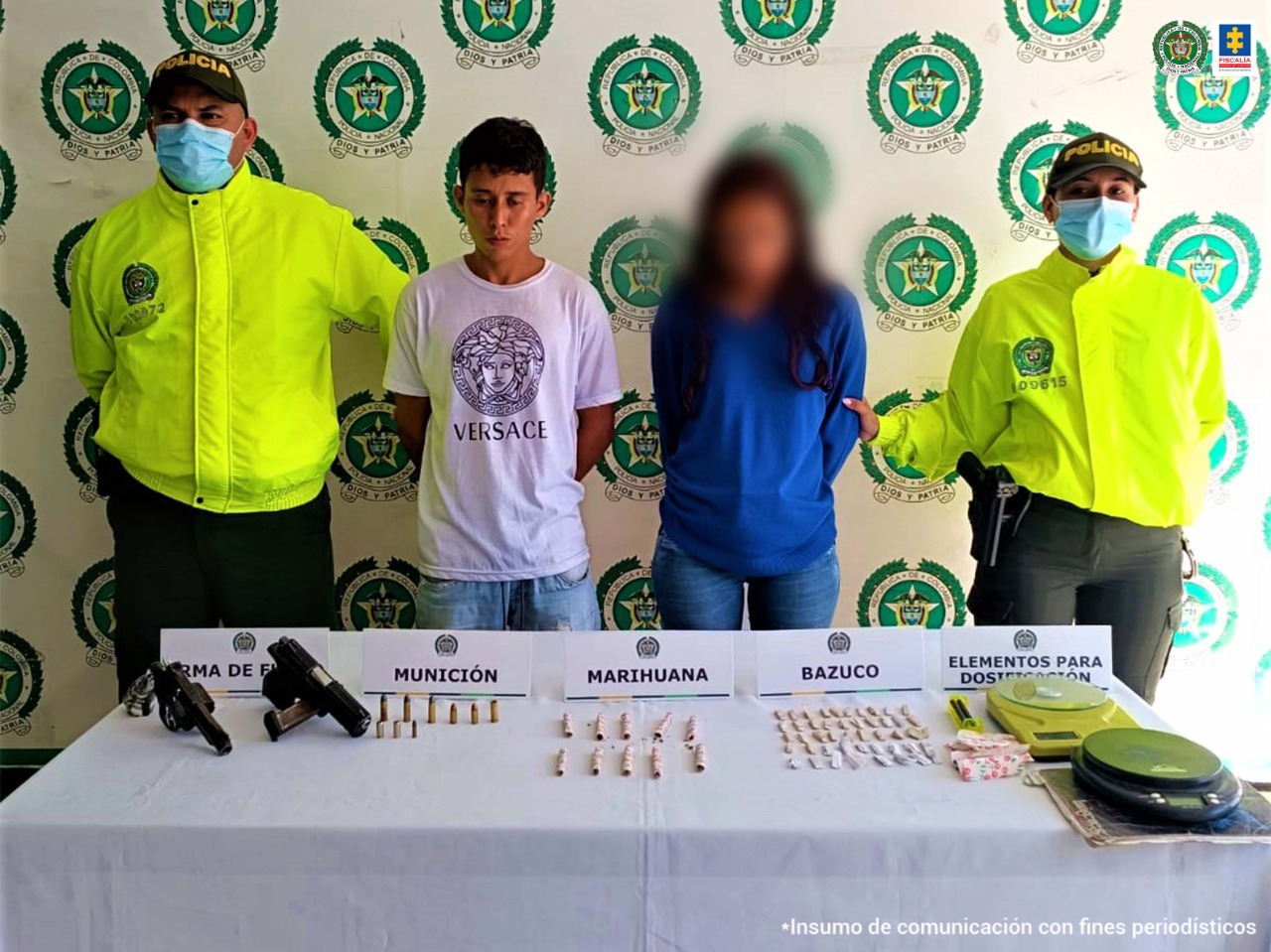 El capturado aparece al lado de dos uniformados de la Policía Nacional y está detrás de una mesa donde se encuentran las armas y los estupefacientes incautados en el allanamiento.