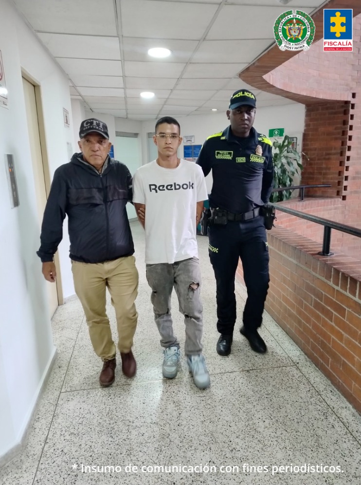 En la fotografía se aprecia en acción de caminata, con los brazos atrás y por un pasillo, a Santiago Maldonado Rodríguez. Viste camiseta blanca de manga corta con la palabra impresa ‘Reebok’ a la altura del pecho; pantalón Caqui desgastado y zapatillas blancas. Asimismo, usa lentes transparentes. Al lado derecho de él hay un servidor del CTI de la Fiscalía y a la izquierda un uniformado de la Policía Nacional.