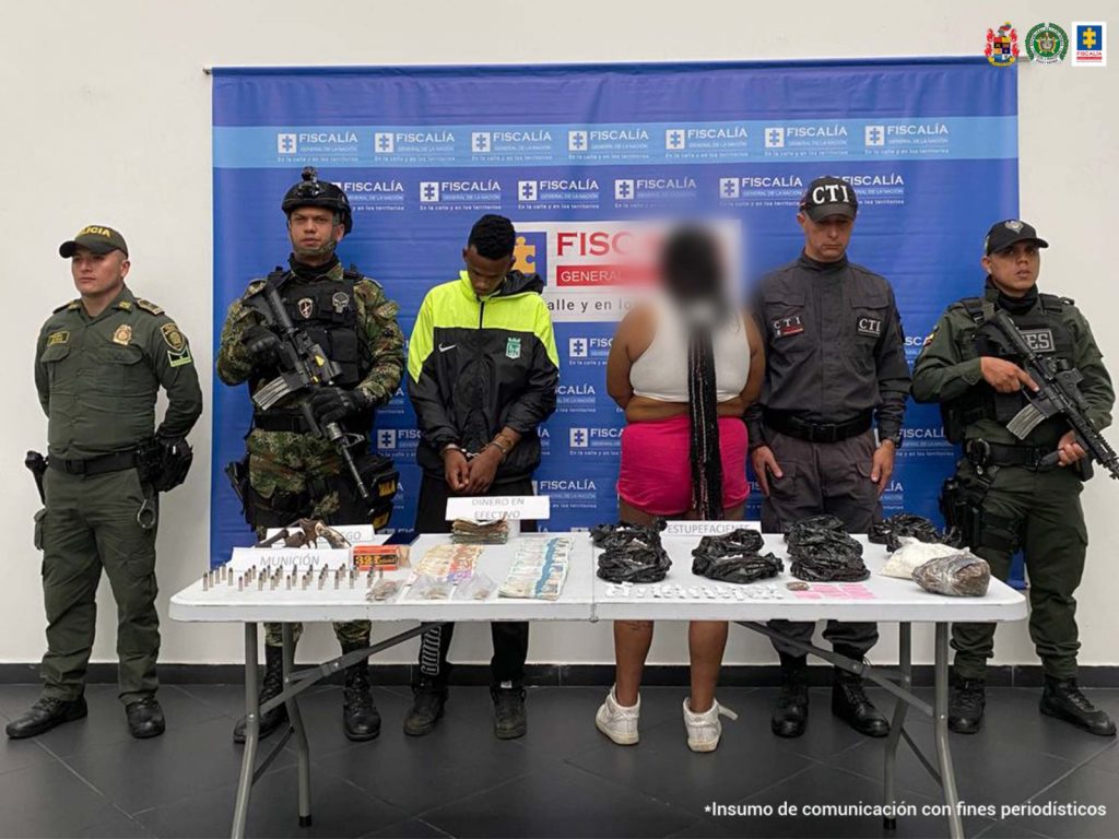 Se observa al capturado en el centro y a su lado una mujer de espaldas cubierta con efecto. En ambos costados uniformados de CTI, Policía Nacional y Ejército