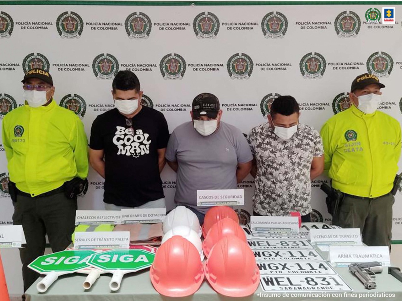 En la foto apreciamos a tres de los capturados en compañía de dos agentes de la Policía Nacional. Se aprecia una mesa que tiene cascos, placas falsas y adhesivos que, al parecer, usaban los procesados para cometer los hechos delictivos.