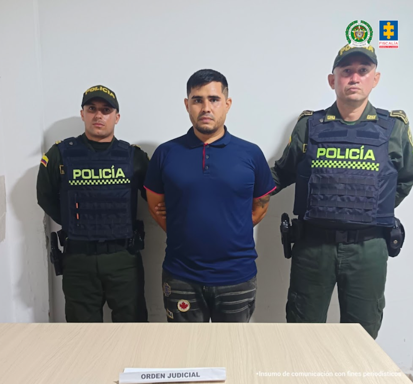 Se visualiza al capturado junto a dos uniformados de la Policía Nacional.