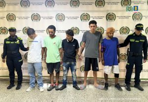 En la imagen están los 5 procesados con 2 servidores de la Policía Nacional a los lados.