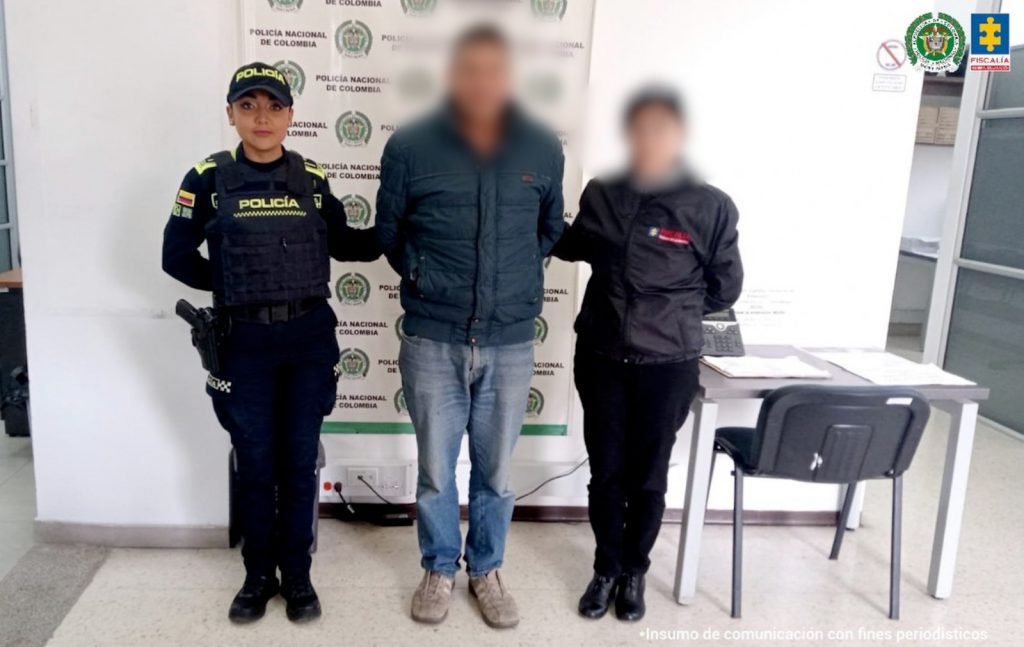 fotografia del capturado con rostro borroso en medio de una policia y un funcionarios del CTI