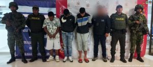 En la fotografía aparecen los tres capturados junto a un servidor del CTI, dos agentes de la Policía Nacional y dos soldados del Ejército. En la parte superior están un banner de la Fiscalía General de la Nación y un banner del Ejército Nacional