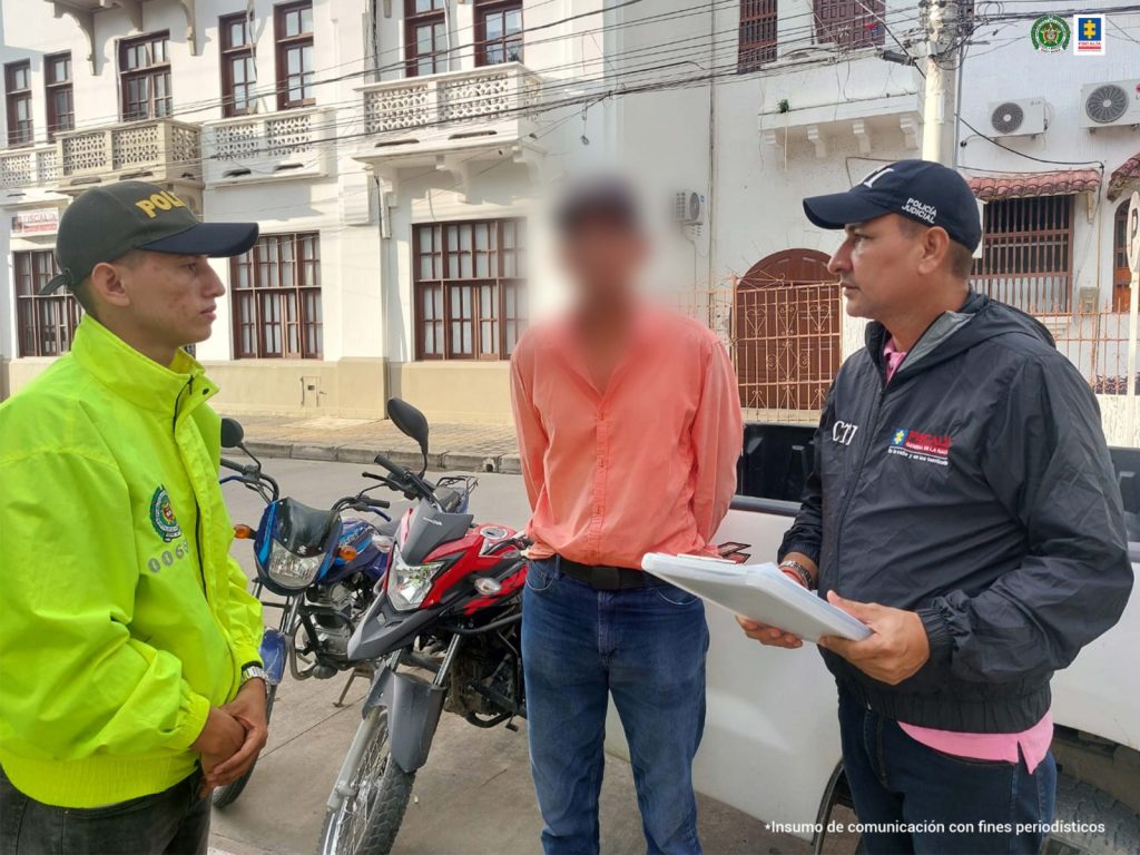 En la imagen se ve una persona capturada entre dos funcionarios de la Policía y la Fiscalía.