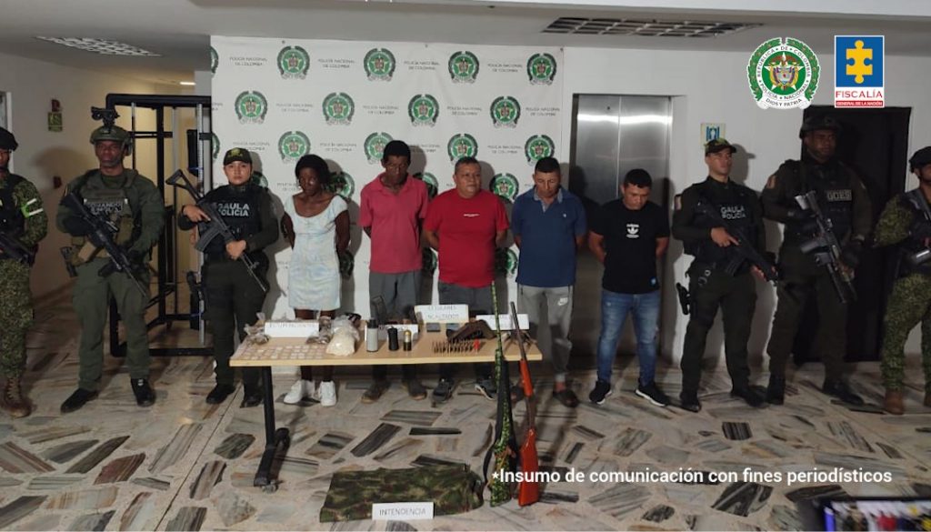 En la fotografía aparecen los cinco capturados junto cinco uniformados de la Policía y dos soldados del Gaula Militar. En la parte posterior está una mesa con estupefacientes, armas de fuego, munición, explosivos y dos teléfonos celulares