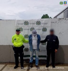 En la imagen se ve a un hombre capturado en medio de un uniformado de la Policía y un funcionario del CTI.