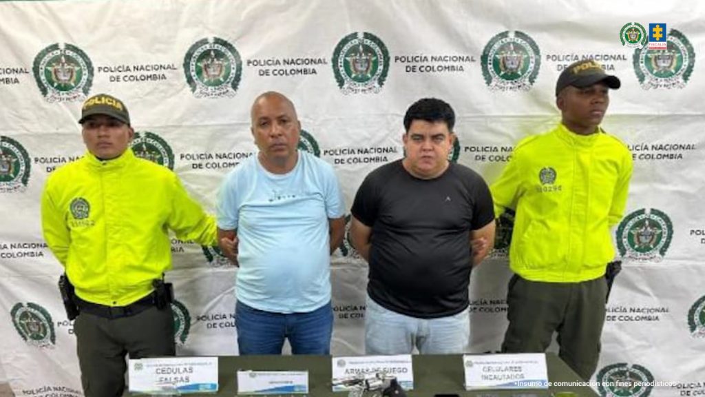 En la fotografía se observan cuatro personas dos de ellas los capturados y dos uniformados de la Policía Nacional.