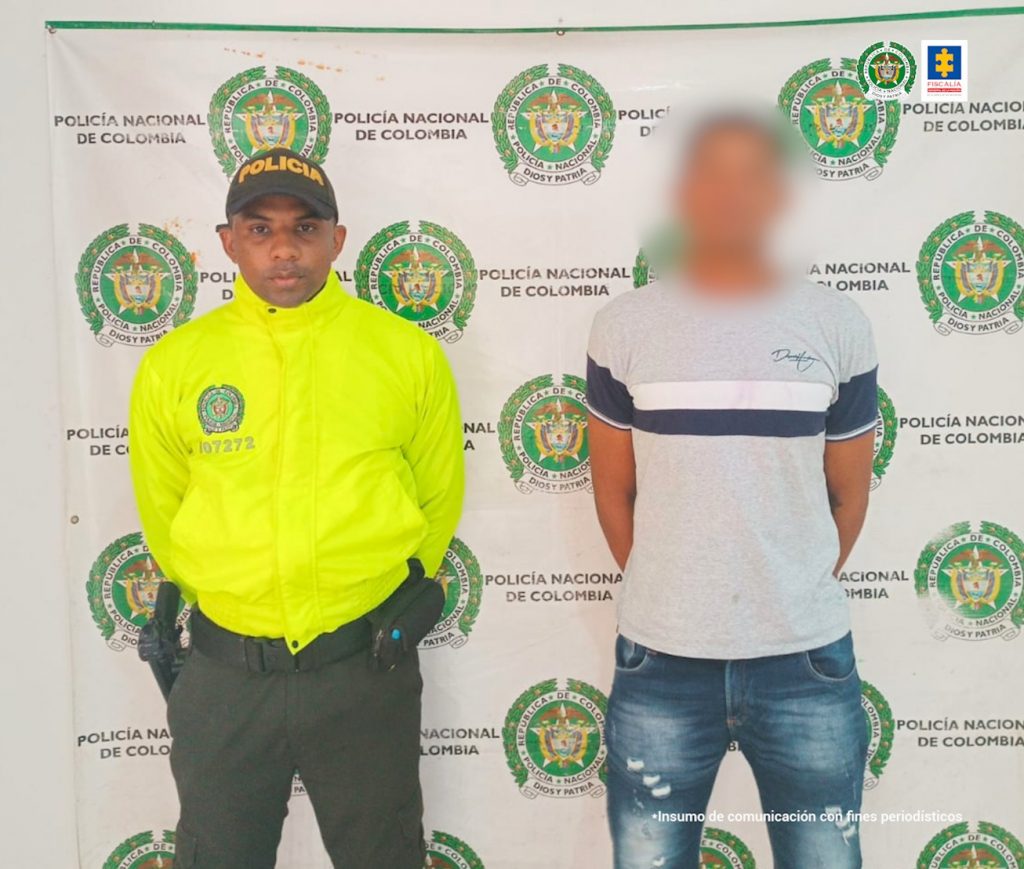 Un uniformado de la Policía Nacional de Magdalena custodia al capturado quien está esposado.