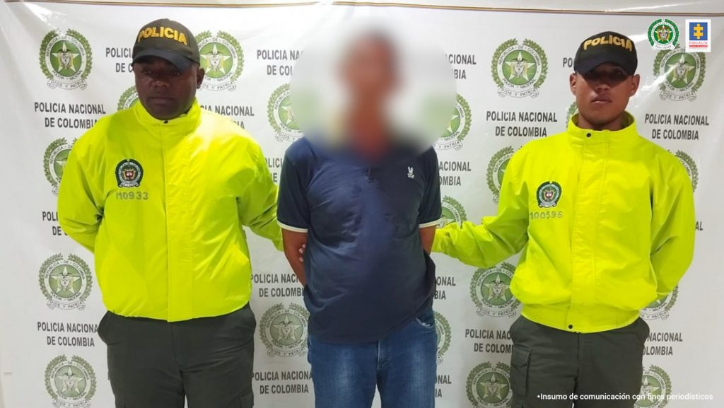 En la imagen se ve una persona detenida entre dos uniformados de la Policía.
