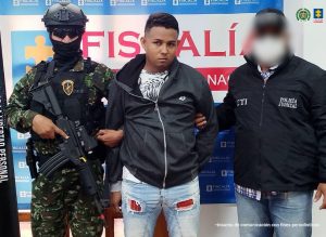 En la imagen aparece una persona de jean, con chaqueta negra, entre dos uniformados del CTI y la Policía Nacional.