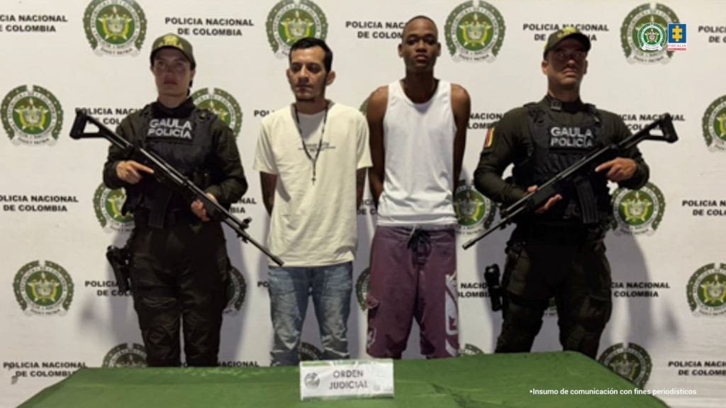 En la fotografía se aprecian de pie y con los brazos atrás a Víctor Manuel Mancilla Mallarino y Vincen Edwar De La Torre Martínez. Uno viste camiseta blanca, de manga corta y con un collar; asimismo, usa jean azul. El otro viste con camiseta esqueleto de color blanco y pantalón color uva. A sus extremos hay uniformados del Gaula de la Policía Nacional. Delante de ellos hay una mesa con mantel verde y sobre ella un letrero que dice: ‘Orden judicial’. Detrás de ellos hay un pendón institucional de la Policía.
