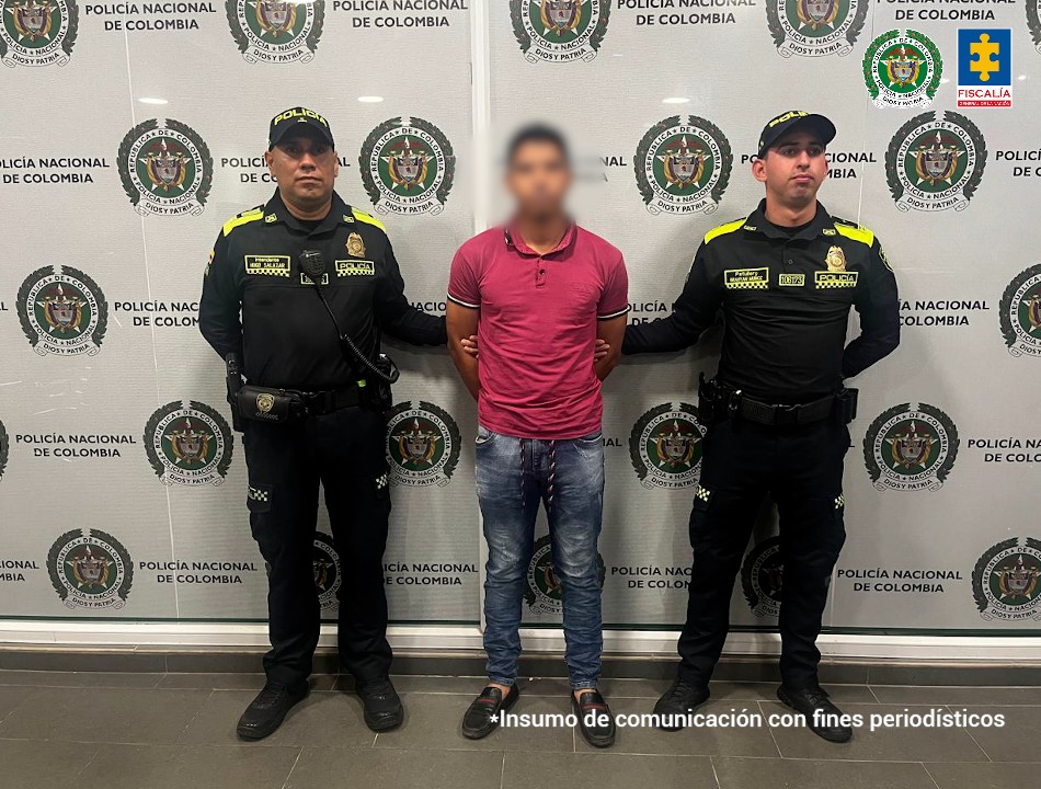 En la foto aparece el capturado de frente y custodiado por dos uniformados de la Policía Nacional. En la foto también aparece de fondo un backing de la Policía Nacional.
