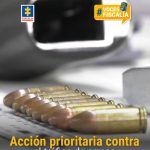 Pieza grafica con los siguientes elementos: En el fondo se observa la parte frontal de un arma de fuego desenfocada y, en primer plano, una fila de proyectiles metálicos (balas) alineados sobre una superficie blanca.En la parte superior izquierda aparece el logotipo de la Fiscalía y en la parte superior derecha un recuadro amarillo con el texto #VocesFiscalía acompañado de un micrófono estilizado.En la parte inferior, en letras grandes amarillas y blancas, está el mensaje central:“Acción prioritaria contra el tráfico de armas”