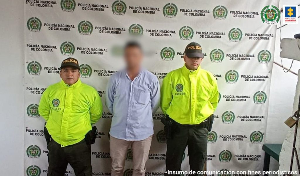 En la foto aparecen dos funcionarios del CTI custodiando al asegurado capturado en Bogotá. 