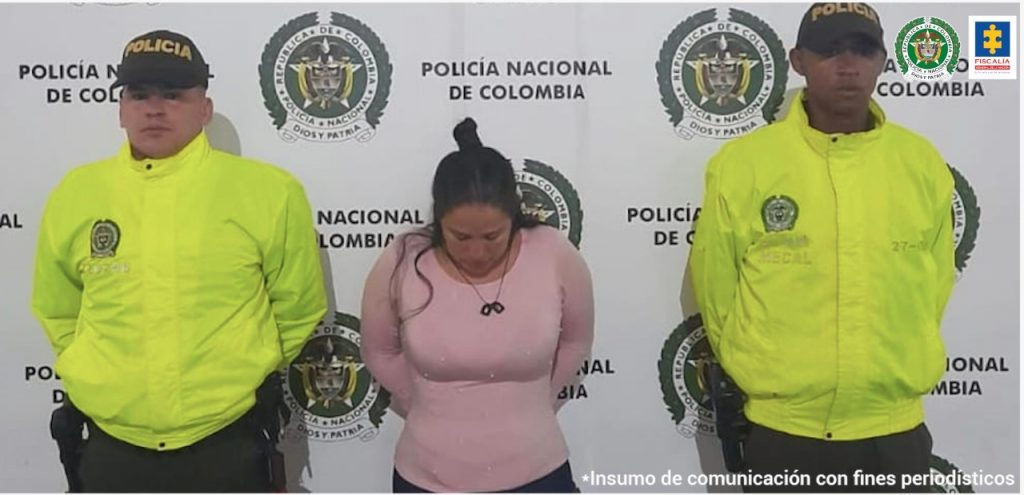 En la fotografía se observa a la capturada junto a dos agentes de la Policía Metropolitana de Cali, Mecal. En la parte superior se observa un banner de la Policía Nacional.