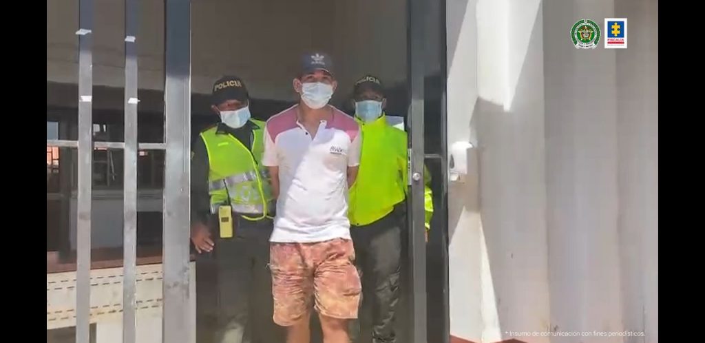 El hoy condenado aparece con tapabocas custodiado por dos miembros de la Policía nacional, en momentos en que era conducido hacia un vehículo de esa institución.