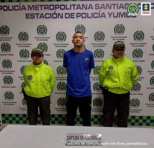 En la fotografía se observa al capturado junto a dos agentes de la Policía Nacional. En la parte superior se observa un banner de la Policía Nacional