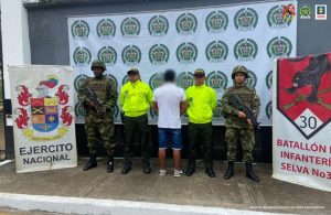 El capturado mestá de espalda y custodiado por unidades del ejército y la policía..