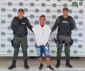 En la imagen se ve una persona capturada entre dos funcionarios de la Policía.