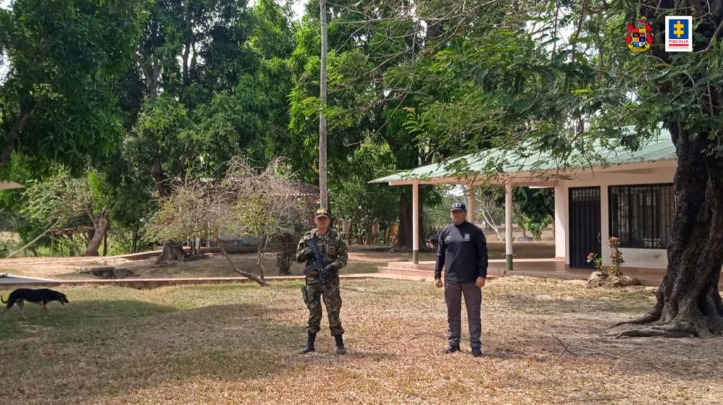 En la imagen se aprecia un predio rural afectado con medidas de extinción del Derecho de Dominio porque habrían sido adquiridos con dineros producto de las irregularidades detectadas en el proceso de contratación del interconector Tunjuelo – Canoas. Se ven en la toma dos uniformados del CTI que custodian el inmueble.