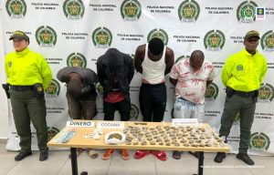 En las fotografías se observan los 4 capturados junto a agentes de la Policía Nacional. En la parte posterior se observa una mesa con dinero en efectivo, cocaína y marihuana.