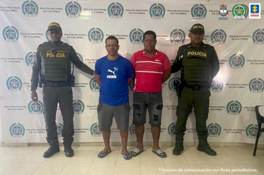 En la fotografía aparecen los dos capturados junto a dos agentes de la Policía Nacional. En la parte superior se observa un banner de la Policía Nacional 