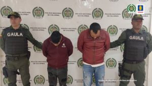 En la fotografía se observan los dos capturados junto a dos agentes del Gaula de la Policía. En la parte superior se observa un banner de la Policía Nacional