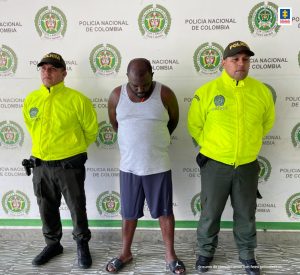 En la fotografía aparece el capturado junto a dos agentes de la Policía Nacional. En la parte superior se observa un banner de la Policía Nacional