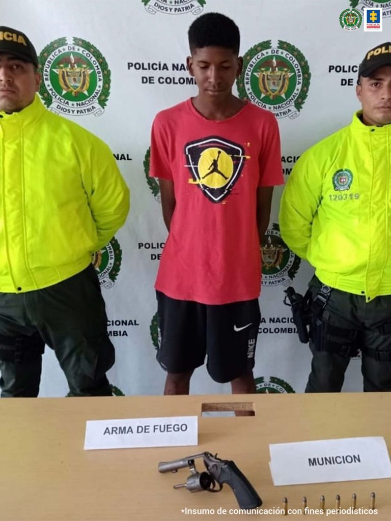 En la fotografía se observa los dos capturados junto a dos agentes de la Policía. En la parte superior se observa un banner de la Policía Nacional