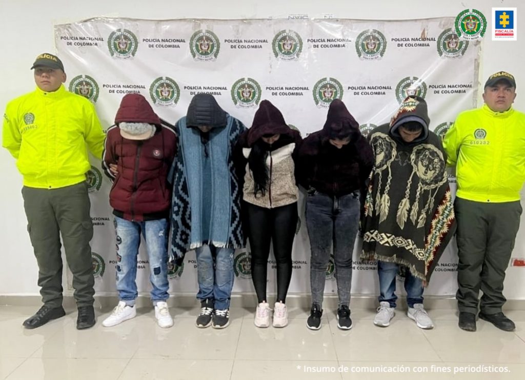 En la fotografía aparecen los 5 capturados junto a dos agentes de la Policía Nacional. En la parte superior se observa un banner de la Policía Nacional