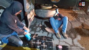 Servidores de la policía judicial del CTI inspeccionan la llanta de repuesto del camión. En dicho lugar iban ocultos 1.300 millones de pesos en efectivo.