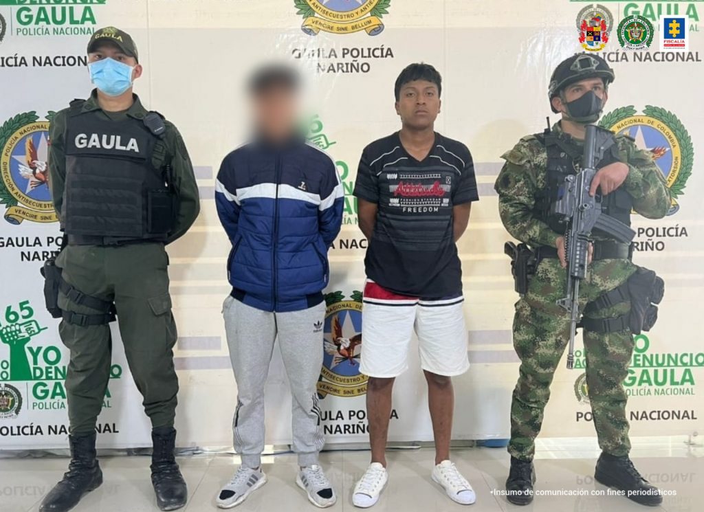 En la fotografía aparece el capturado junto a un agente del Gaula de la Policía y un soldado del Gaula militar. En la parte superior se observan un banner de la Policía Nacional y un banner del Gaula Militar