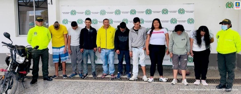 En la fotografía aparecen los capturados junto a dos agentes de la Policía Nacional. En la parte superior está un banner de la Policía Nacional