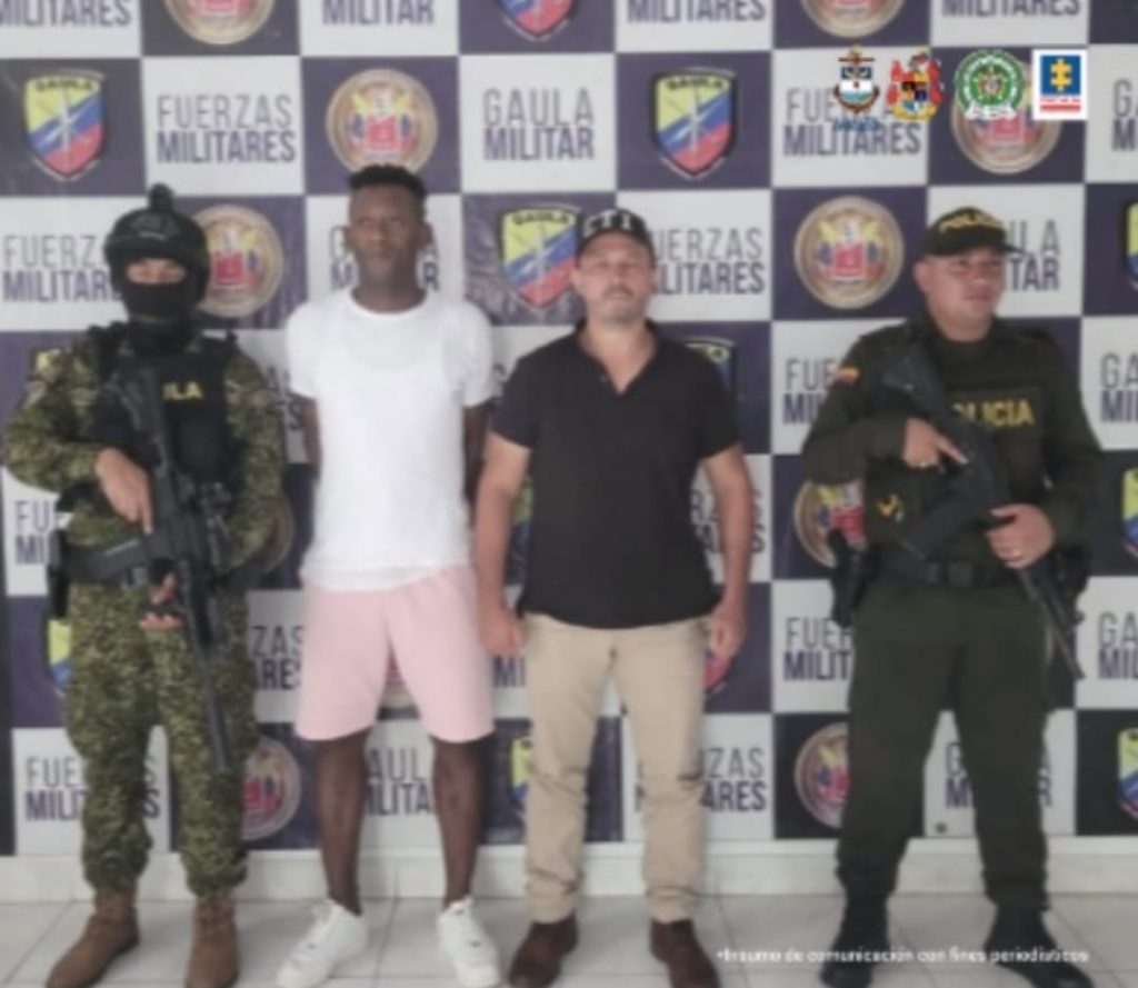 En la fotografía aparece el capturado junto a un servidor del CTI, un agente de la Policía Nacional y un soldado del Gaula militar. En la parte superior está un banner del Gaula Militar