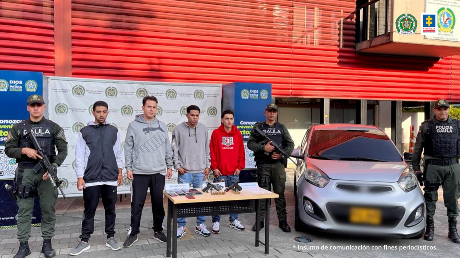 Aparece un grupo de personas capturadas, junto a las autoridades y un vehículo gris.