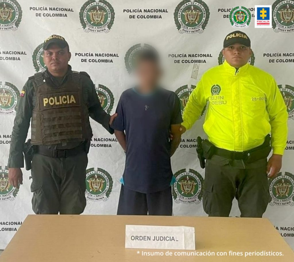 En la fotografía aparece el capturado junto a dos agentes de la Policía Nacional. En la parte superior está un banner de la Policía Nacional